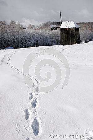 Human traces in the snow leading to the old mill. Stock Photo