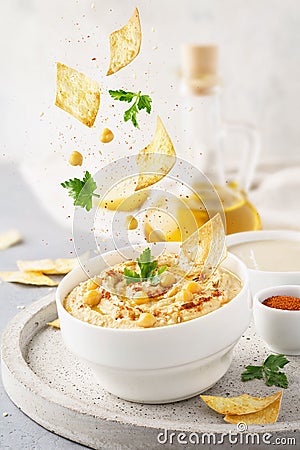 Hummus bowl and falling ingredients. Food levitation Stock Photo