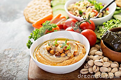 Hummus and vegetables platter with grain salad Stock Photo