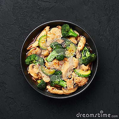 Hunan Chicken in black bowl at dark slate background. Chinese or indo-chinese cuisine takeaway dish Stock Photo