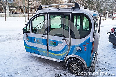 Three-wheel motor scooter with a cab on the streets of Hunchun in China Editorial Stock Photo