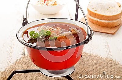 Hungarian carp soup in a kettle and sour salad Stock Photo