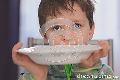 Hungry boy with beautiful eyes waiting for dinner Stock Photo