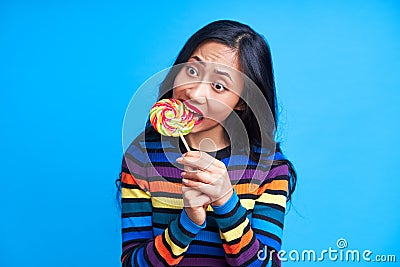 Hungry funny woman bite delicious colorful lollipop Stock Photo