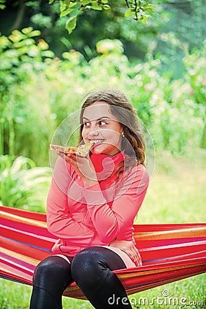 Hungry girl eating pizza slice sit hammock, summer picnic concept Stock Photo