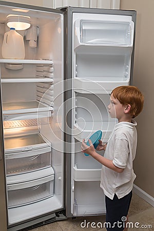 Hungry little boy looking into empty fridge Stock Photo