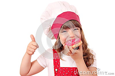 Hungry little girl cook eat donuts Stock Photo