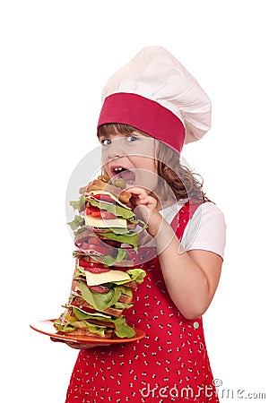 Hungry little girl cook eat sandwich Stock Photo