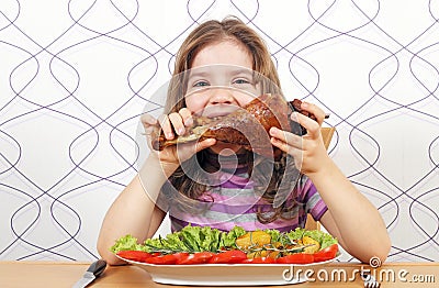 Hungry little girl eating turkey drumstick Stock Photo