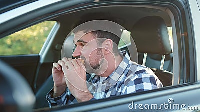 Hungry male driver eating snack in the car. Transport, food, lifestyle, people concept. Stock Photo