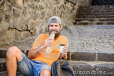 Hungry man snack. Junk food. Guy eating hot dog. Man bearded enjoy quick snack and drink paper cup. Street food so good Stock Photo
