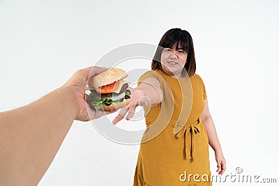 Hungry overweight young Asian woman holding hamburger on isolated background, Her hungry all time and overeat, gluttony and binge Stock Photo