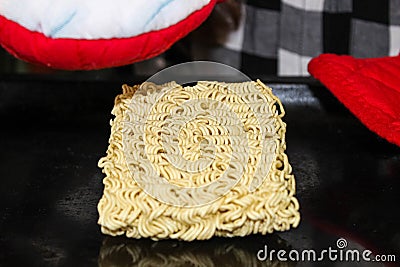 A hungry person about to cook instant noodles on a baking sheet in the oven Stock Photo