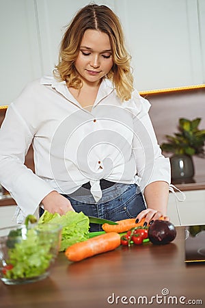 Attentive young woman cooking salad for dinner Stock Photo