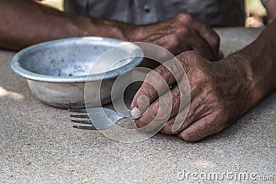 Hungry. Poor old man& x27;s hands an empty bowl. Selective focus. Poverty in retirement. Alms Stock Photo