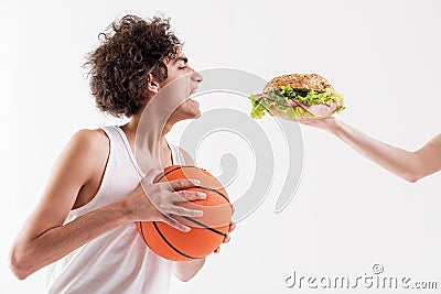 Hungry thin young man holding ball Stock Photo