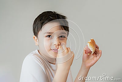 Hungry young boy eating homemade bacon sandwiches with mixed vegetables, Healthy Kid having breakfast at home, Child bitting Stock Photo