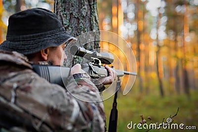 Hunter looking into rifle scope Stock Photo