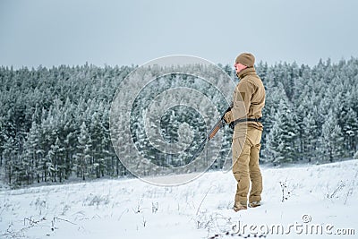 Hunter man dressed in camouflage clothing standing in the winter Stock Photo