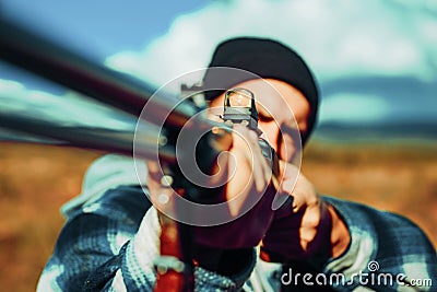 Hunter man. Hunter Target with laser sight. Collimating sight. Hunter with shotgun gun on hunt. Hunter aiming rifle in Stock Photo