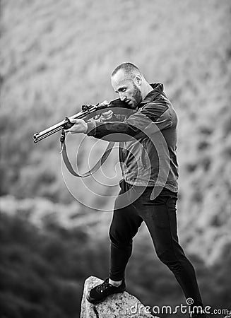 Hunter poacher looking for victim. Hunter with rifle nature environment. Poaching concept. Man brutal poacher with Stock Photo