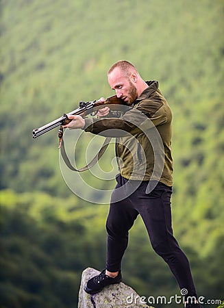 Hunter poacher looking for victim. Hunter with rifle nature environment. Poaching concept. Man brutal poacher with Stock Photo