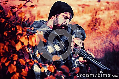 Hunter with shotgun gun on hunt. Autumn hunting season. Closed and open hunting season. Poacher in the Forest. Mountain Stock Photo