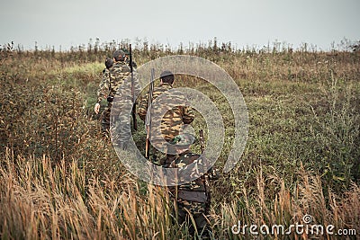 Hunters going up through rural field during hunting season Stock Photo