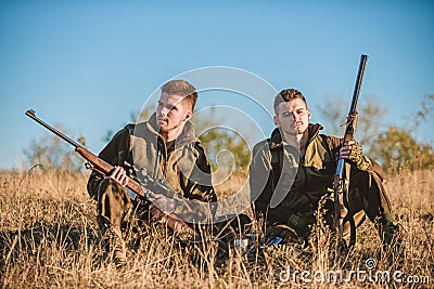 Hunters with rifles relaxing in nature environment. Hunting with friends hobby leisure. Hunters friends enjoy leisure Stock Photo