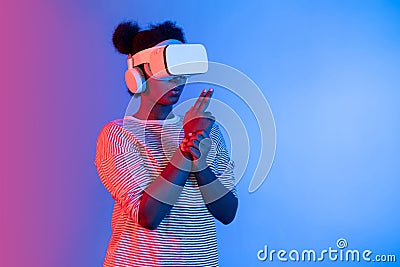 African gamer wearing VR turning meta world playing gun shooting. Contrivance. Stock Photo