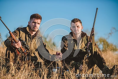 Hunting with friends hobby leisure. Hunters with rifles relaxing in nature environment. Hunters satisfied with catch Stock Photo