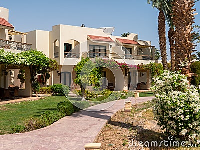 Hurghada, Egypt- September 22, 2021: View of the green area of the hotel with two-storey houses. Beautiful bright flowers are Editorial Stock Photo