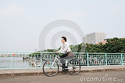 Hurry Asian businessman riding bike in rush hour. Young man late for train work, meeting. Stock Photo