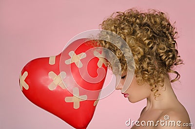 Hurt woman with ball in shape of heart Stock Photo