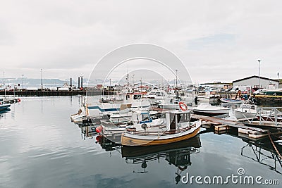 boats reflected in calm water of harbour husavik iceland Editorial Stock Photo