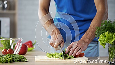 Husband cutting fresh salad on board for healthy family lunch, cooking help Stock Photo