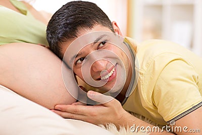 Husband listening to belly of his pregnant wife Stock Photo