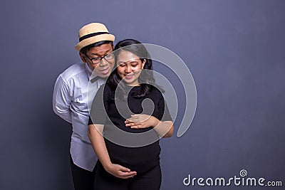 Husband and pregnant wife both take a look at their baby inside the belly Stock Photo