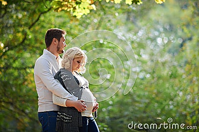 Husband and pregnant wife are walking in the park Stock Photo