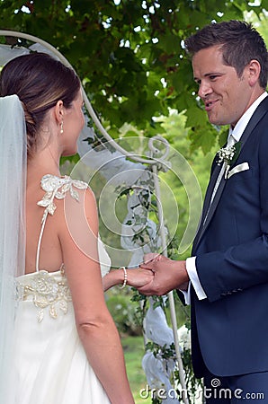 Husband puts a wedding ring on bride's finger on their wedding D Stock Photo