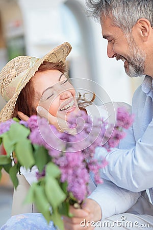 Husband surprises his wife with a bouquet of lilacs Stock Photo