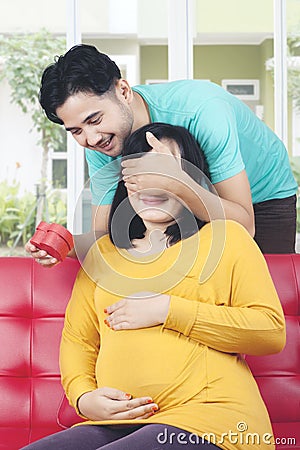 Husband surprises pregnant wife with gift Stock Photo