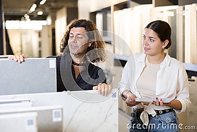 Husband and wife choose and buy ceramic flooring together Stock Photo