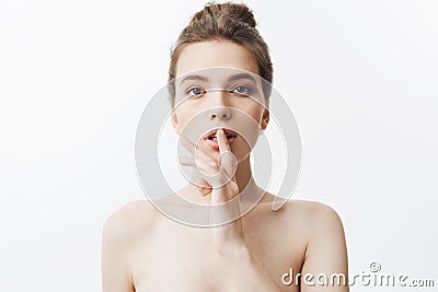 Hush. Close up portrait of charming good-looking caucasian youn woman with dark hair in bunan hairstyle and naked body Stock Photo