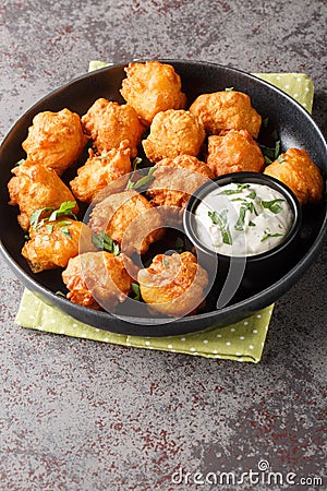 Hush puppies, southern food, deep fried cornbread balls closeup on the plate. Vertical Stock Photo