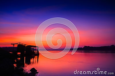 Hut reflection on water under colorful sky Stock Photo