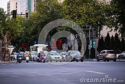 Huzhou, China 2020 September 28: Electric scooters and Car rush hours city street. Cars on road in traffic jam on Editorial Stock Photo