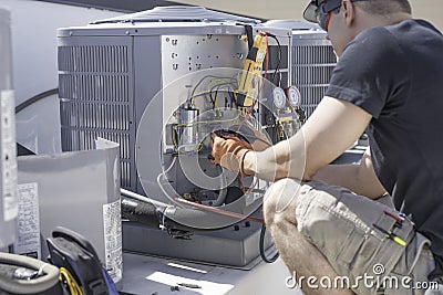 HVAC technician working on controls of air conditioner Stock Photo