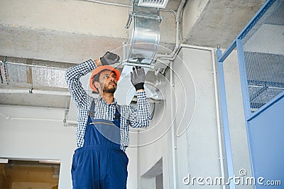 hvac services - indian worker install ducted pipe system for ventilation and air conditioning in house Stock Photo
