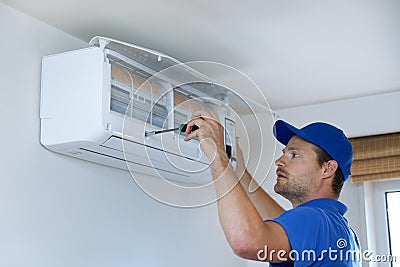 hvac services - technician installing air conditioner on the wall Stock Photo